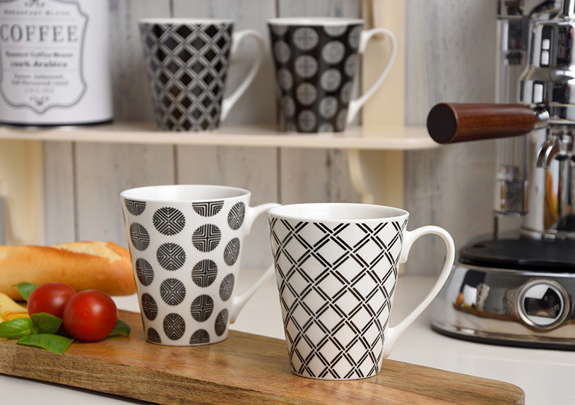 Becher schwarz Retro aus Porzellan, 4-fach sortiert, 10 cm, 350 ml Kaffeebecher, Tassengestell, Geometrische Muster, Schwarz-Weiß Muster, Espressomaschine im Hintergrund