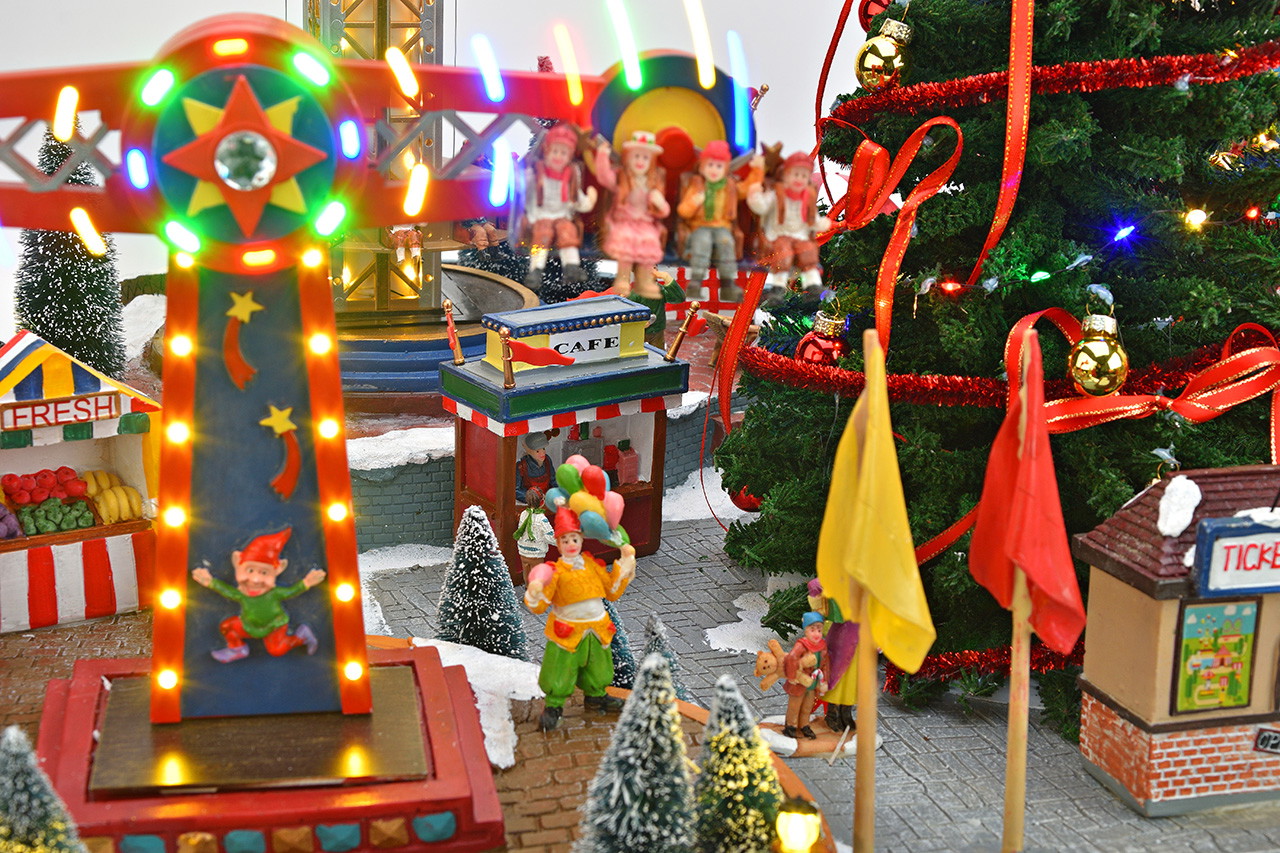 Weihnachtsdorf, Miniaturkirmes, beleuchtetes Karussell, Weihnachtsbaum, Weihnachtsdekoration